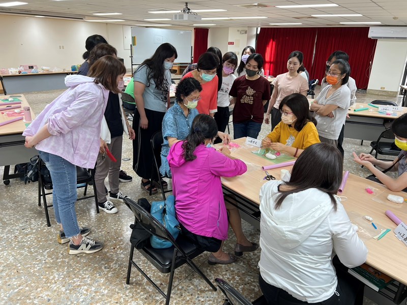 學員們聚集在講座身邊並認真聽其示範紙黏土訣竅